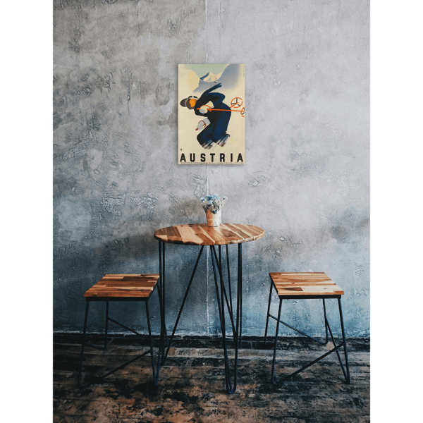 A vintage Austrian ski sign hung up on a wall above a small table and chairs.