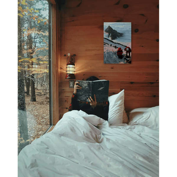 An image depicting climbers on Mt Rainier hanging on a wall in a cabin above a bed.