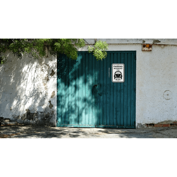 An image of a parking sign hung up on a garage door outside.